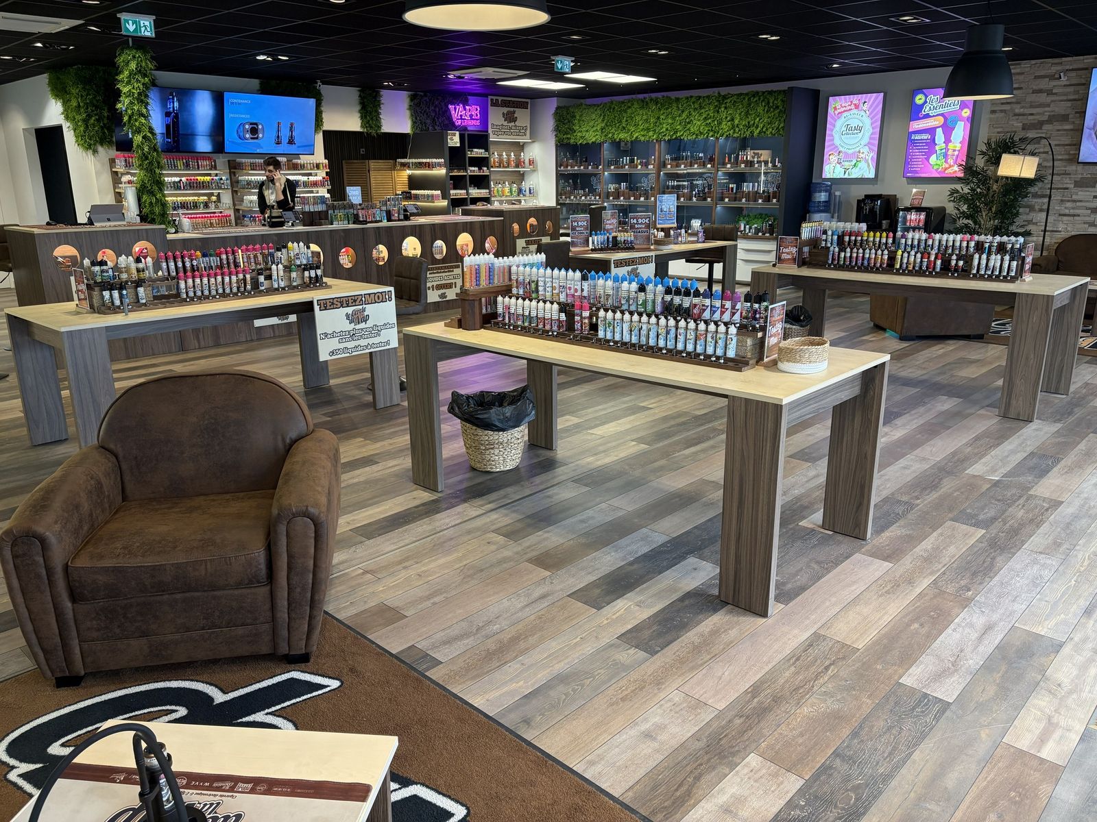 Intérieur de la boutique : tables d'e-liquides en test libre